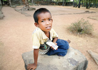 A child begs for money at Ta Prohm temple near Tonle Bati. He fares quite well with tourists who visit both the temple and nearby lake.