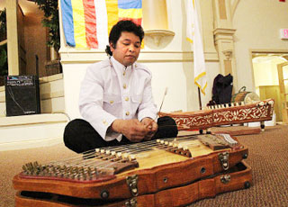 Vith Chrorm, of Attleboro, performs at Rhodes on the Pawtuxet Saturday as part of a celebration for the Cambodian New Year. The event included music, dance and displays on Cambodian history.
