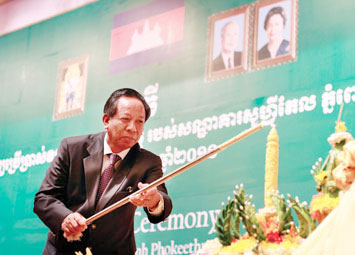 Deputy Prime Minister Tea Banh lights a candle during the ceremony for the grand opening of the five-star Sofitel Phnom Penh Phokeetra hotel yesterday.